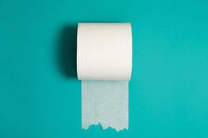 a toilet paper roll on a colorful background symbolizing incontinence