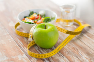 close up of green apple and measuring tape