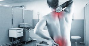 a man holds his shoulders and lower back in pain