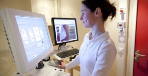 an ultrasound technician reviews a breast ultrasound