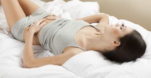 a woman with crohns disease holds her stomach in pain