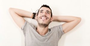 a young man lies on a bed happy that he is managing his crohn's disease